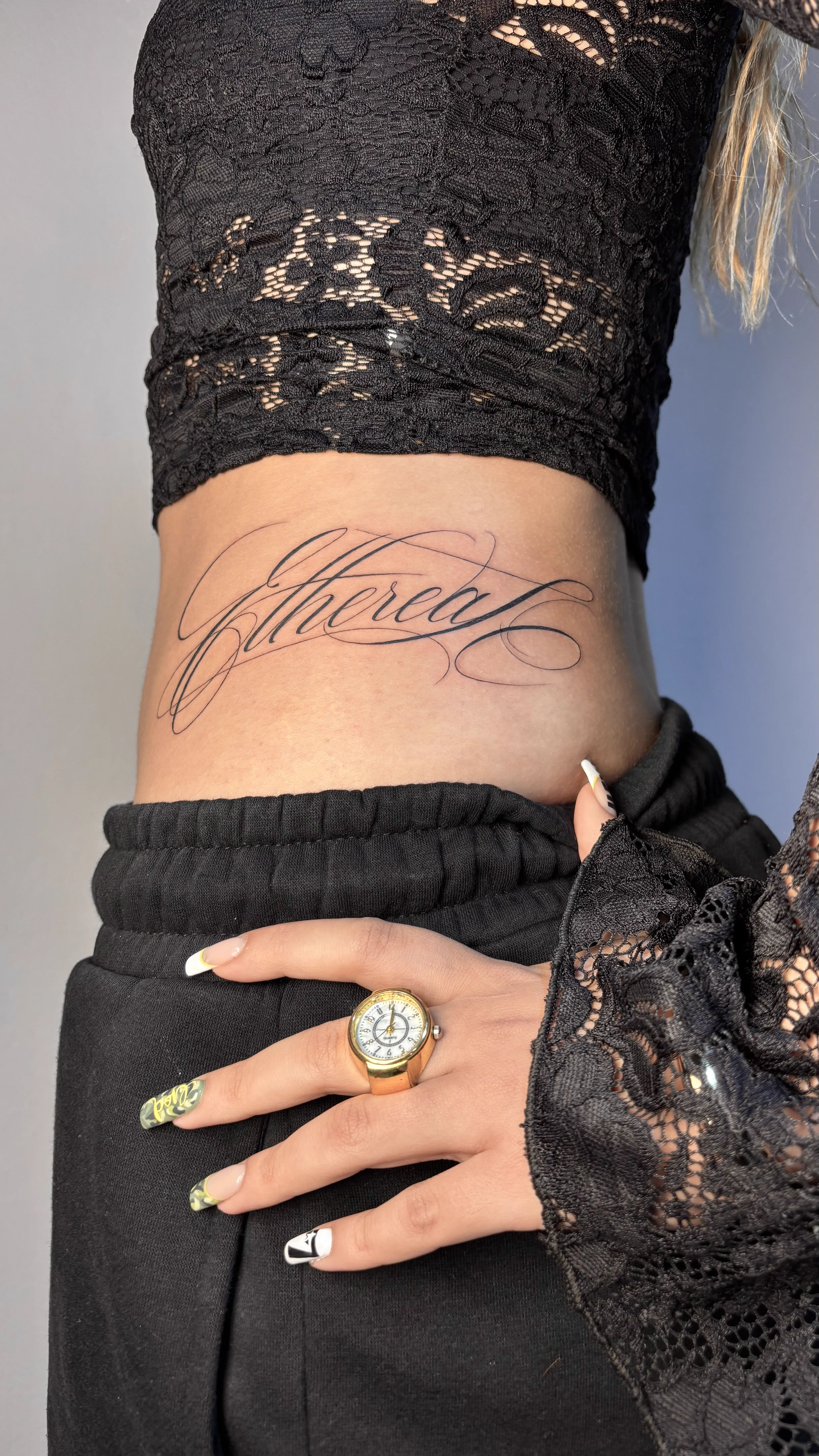 Tatuagem lettering delicada na lateral do corpo
