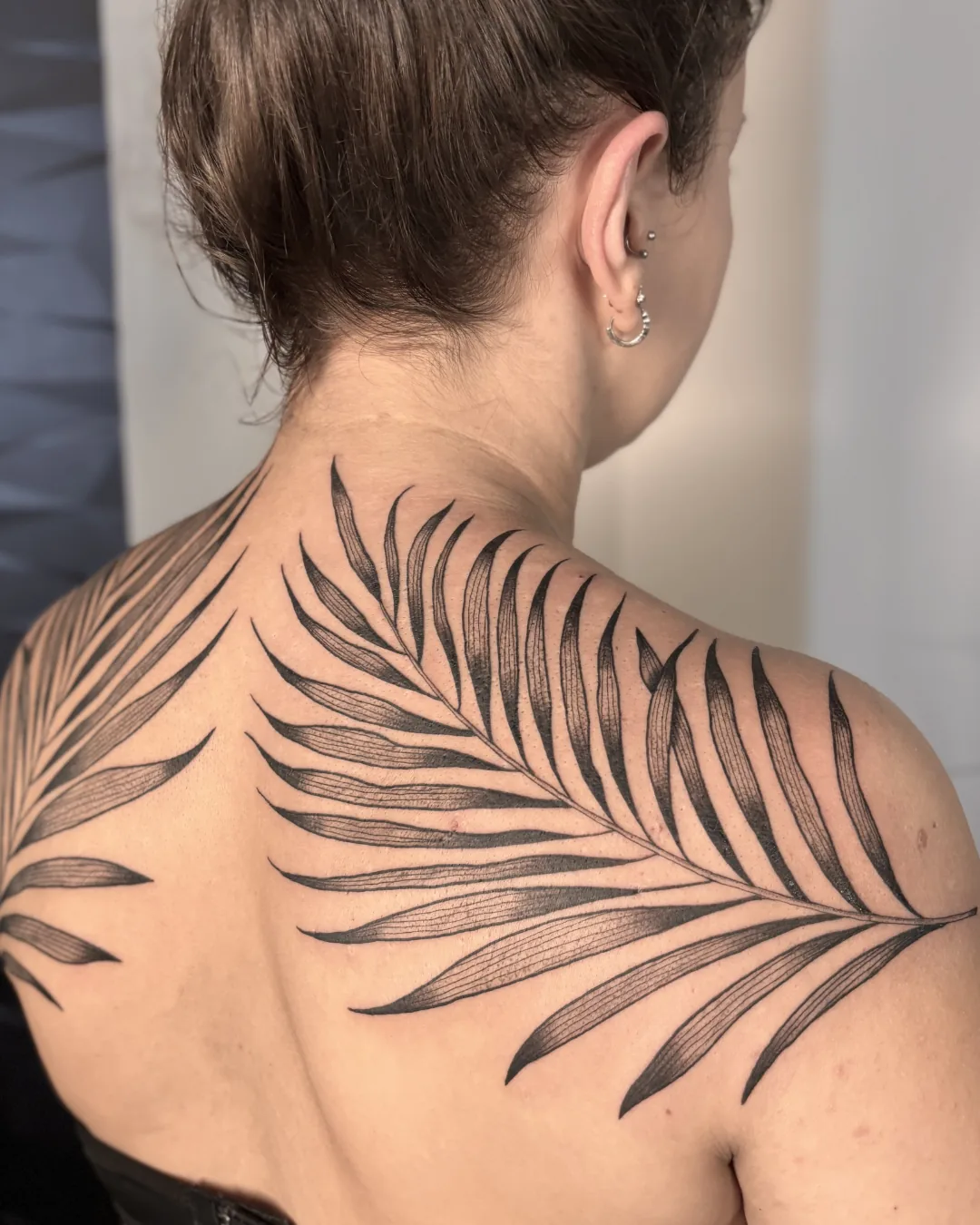 Tatuagem de folhagem nas costas em traços finos